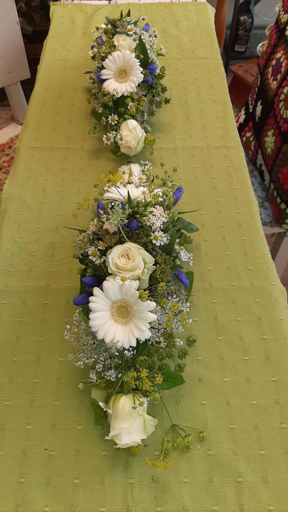 weiß-lila Blumensträuße auf grünem Tisch