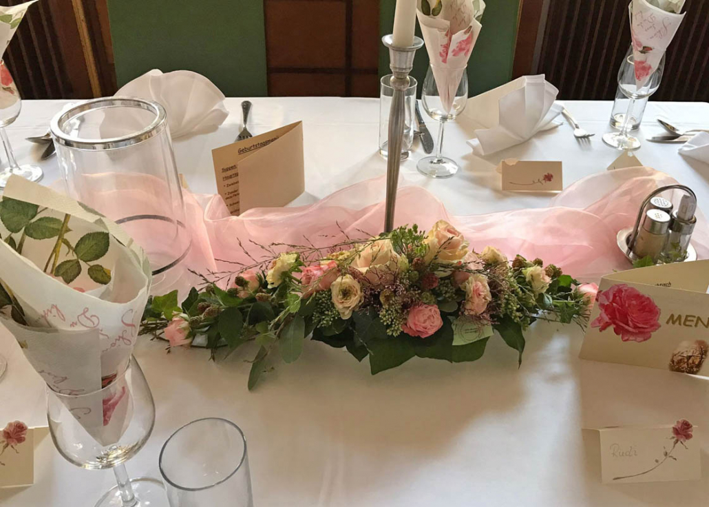 Tischdekoration mit rosa und weißen Blumen
