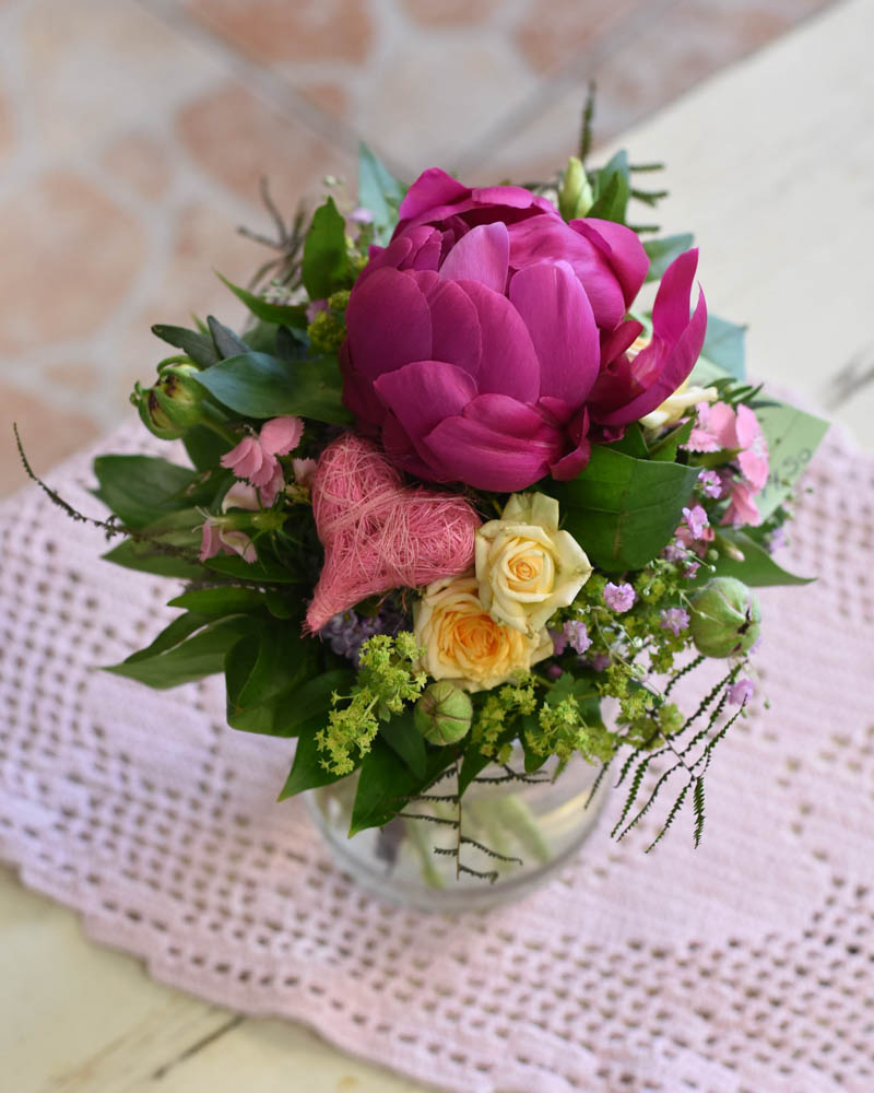 Blumengesteck mit gelben Rosen, großer rosa Rose und rosa Textilherz